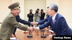 지난 8월 25일 한국 측 대표인 김관진 국가안보실장(오른쪽부터 반시계방향)과 홍용표 통일부 장관, 북측 대표인 김양건 당 비서와 황병서 군 총정치국장이 판문점에서 '무박4일' 마라톤 협상을 마치고 악수하고 있다. (자료사진)