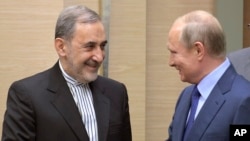 Russian President Vladimir Putin, right, shakes hands with Ali Akbar Velayati, a senior adviser to Iran's Supreme Leader Ayatollah Ali Khamenei, at Novo-Ograyovo outside in Moscow, Russia, Thursday, July 12, 2018.
