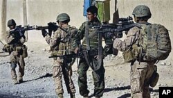 Lance Cpl. Juan Delacerda, of Kerrville, Texas, right, and Lance Cpl. Adam Rader, of Lodi, California, with India company, 3rd Battalion 5th Marines, First Marine Division, accompanied by an Afghan soldier patrol in Sangin, Afghanistan, Nov 11, 2010 (file