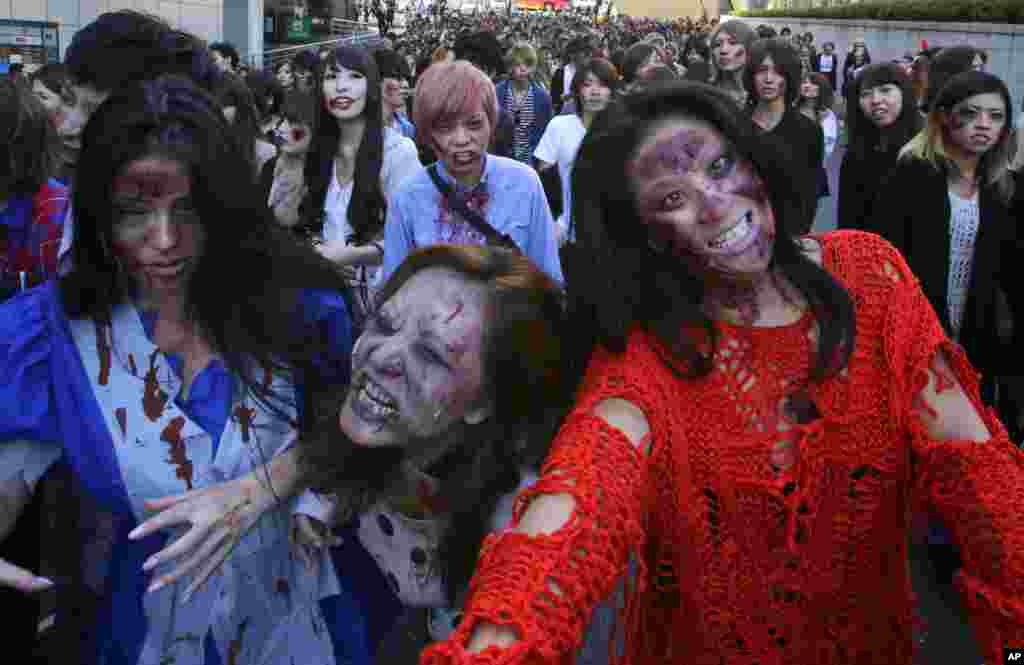 Orang-orang memakai rias wajah zombie dalam sebuah acara Halloween di Tokyo Tower, Tokyo. (AP/Shizuo Kambayashi)