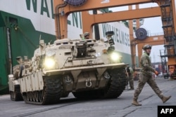 Sebuah tank tempur M1A2 Abrams milik tentara AS yang akan digunakan untuk latihan militer oleh Tim Tempur Brigade Lapis Baja ke-2, di Terminal Kontainer Baltik di Gdynia pada 3 Desember 2022. (Foto: AFP)