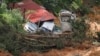 Damaged cars are seen amongst the debris during a rescue and evacuation operation following a landslide at a campsite in Batang Kali, Selangor, Malaysia, Dec. 17, 2022.