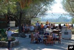 People fill a patio tasting wine and listening to music at the historic Gundlach Bundschu winery in Sonoma, California, Oct.28, 2017.