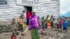 FILE - Pasika Bagerimana stands outside a temporary shelter she shares with others who fled fighting, in Nyiragongo, Democratic Republic of Congo, Aug. 31, 2022. Increased violence in the DRC is leading to a surge of refugees crossing the border into Uganda.