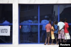 Des gamins regardent les responsables de la CNE durant le dépouillement à Bissau, le 18 mars 2012