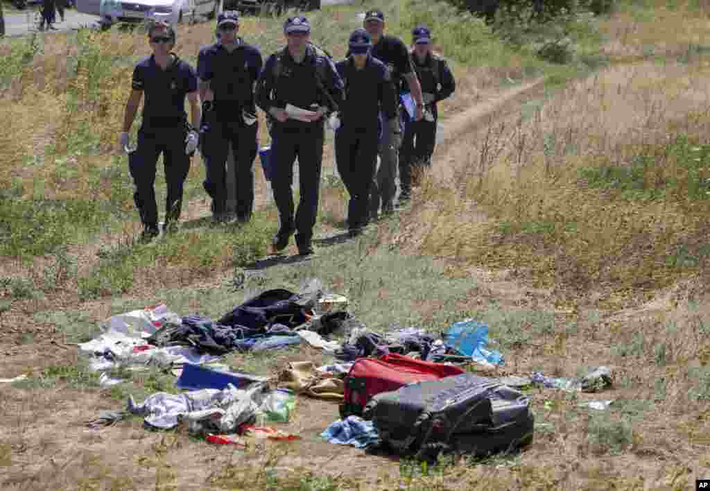 Australian investigators examine the area of the Malaysia Airlines plane crash in the village of Hrabove, Donetsk region, eastern Ukraine, Aug. 1, 2014. 