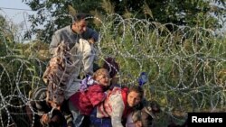 Des migrants syriens passent la frontière entre la Serbie et la Hongrie, en août 2015. (REUTERS/Bernardett Szabo)