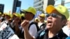 FILE - Taiwanese workers shout slogans during a protest in Taipei, Taiwan, Jan. 4, 2020. Hundreds of workers from various labor groups staged a protest before general elections demanding for better conditions for workers.