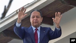 Former dictator Jean-Claude 'Baby Doc' Duvalier waves to supporters from the balcony of a rented guest house where he is staying in Port-au-Prince, Haiti, January 21, 2011
