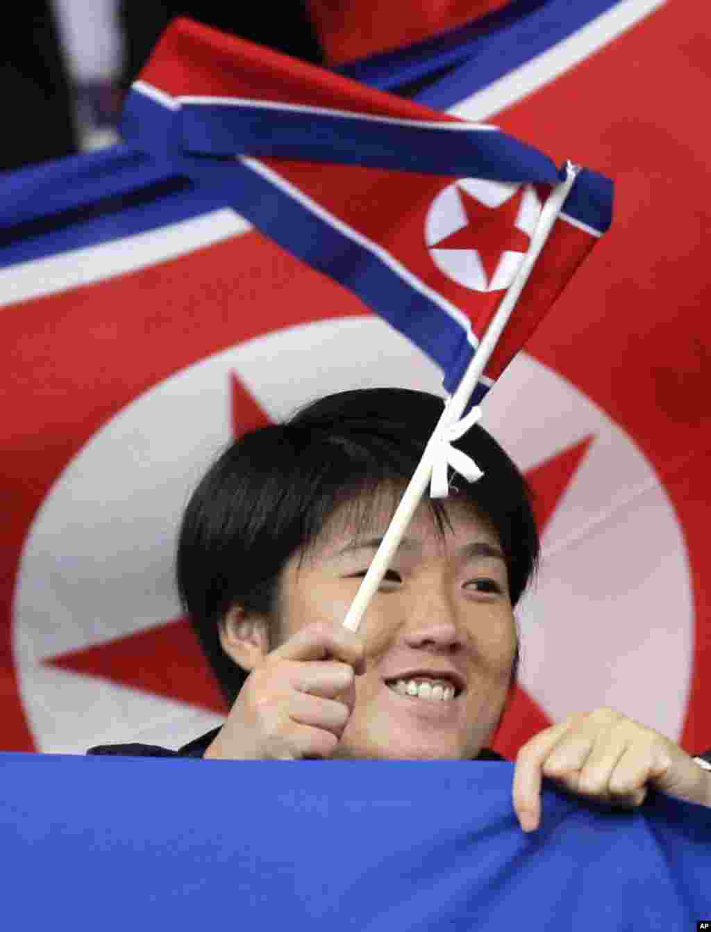 A North Korea supporter waves a flag before the team's group G women's soccer match against the United States at the London 2012 Summer Olympics, July 31, 2012 at Old Trafford Stadium in Manchester, England.