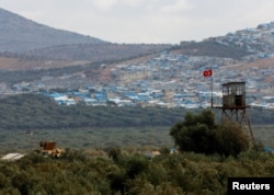 FILE - A Turkish military armored vehicle patrols the border line opposite the Syrian town of Atimah, Idlib province, in this picture taken from Reyhanli, Hatay province, Turkey, Oct. 10, 2017.