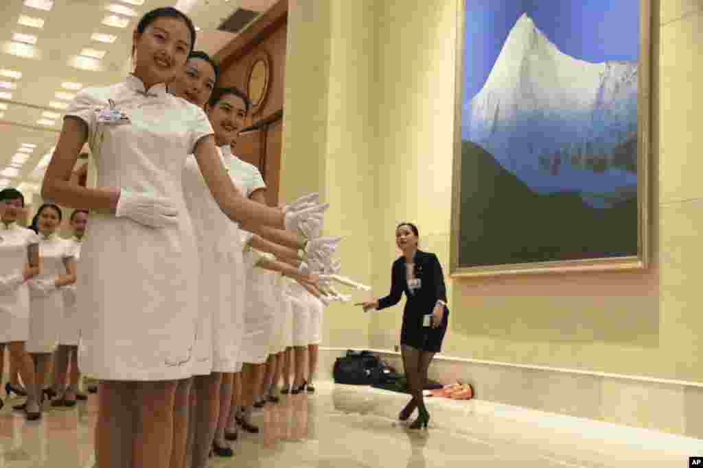 Hostesses pose for photos during a break from the G20 Finance Ministers and Central Bank Governors meeting in Chengdu in Southwestern China's Sichuan province.