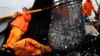 FILE - Fishermen work to unload a net full of anchovies during a fishing expedition in the Pacific Ocean, off the coast of El Callao, Peru, Nov. 22, 2012.