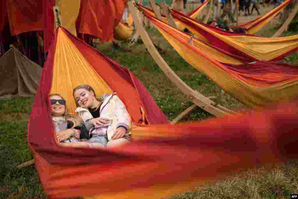在英国西南部举行的格拉斯顿伯里当代表演艺术节（Glastonbury Festival）期间，有人躺在吊床上（6月25日）。这是目前世界最大的的露天音乐节和表演艺术节。