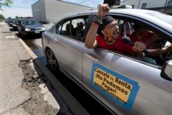 FILE - In this May 30, 2020, photo, a car caravan calling for the cancellation of rents during the coronavirus pandemic prepares to parade through Boston.