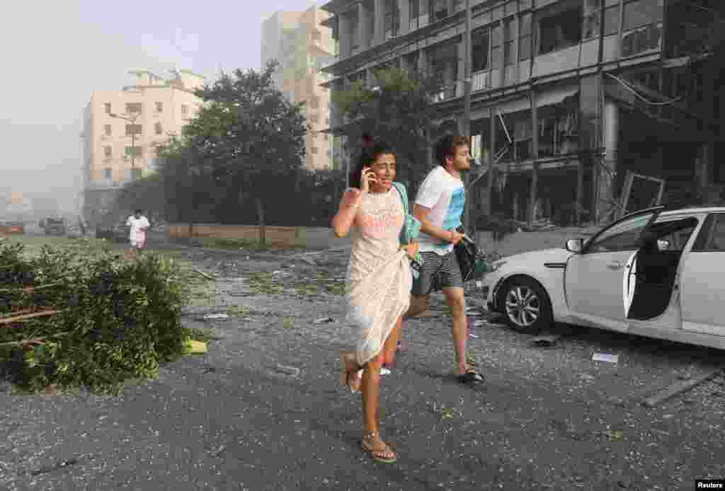 People run for cover following an explosion in Beirut's port area, Lebanon, Aug. 4, 2020.