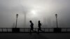 FILE - People jog past the Pudong Financial District shrouded in fog and pollution at the Shanghai Bund in Shanghai, China, Thursday, April 14, 2016. Air pollution has caused 5.5 million premature deaths globally in 2013, outpacing disease, a new study has found.