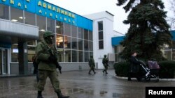Pria-pria bersenjata berpatroli di bandar udara di Simferopol, Krimea (28/2).