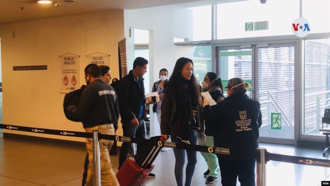 Migrantes pasan por el control en el Aeropuerto Internacional El Dorado, en Bogotá. Las Autoridades de Migración de Colombia y el Ministerio de Salud de Colombia han reforzado los protocolos.