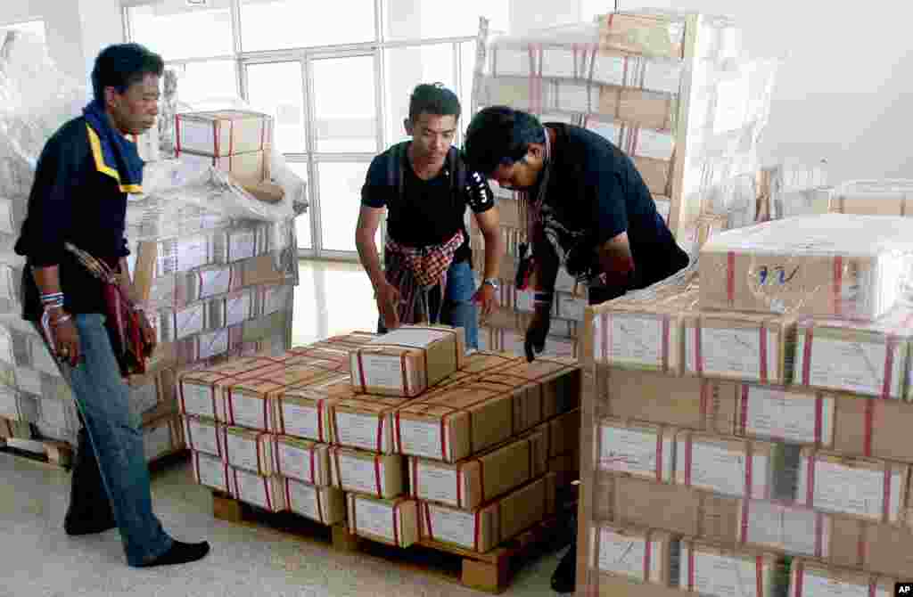 Anti-government protesters check voting ballots they seized to disrupt elections before handing the papers back to officials after the general election in Hat Yai district, Songkhla province, southern Thailand, Feb. 2, 2014.