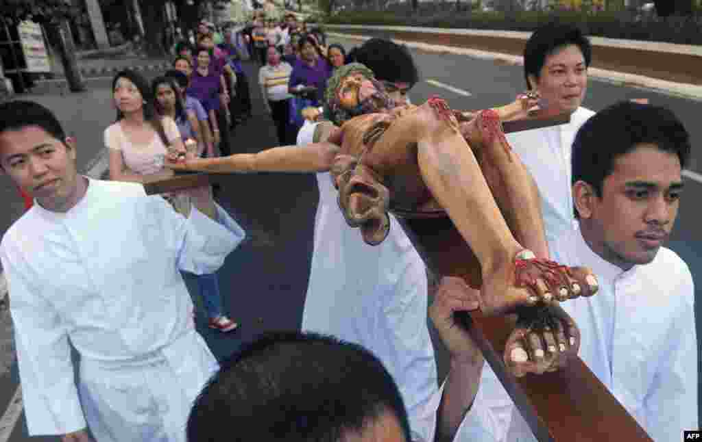 An effigy of Jesus Christ on the cross is carried by devotees during a Good Friday procession in Manila, The Philippines, April 3, 2015.