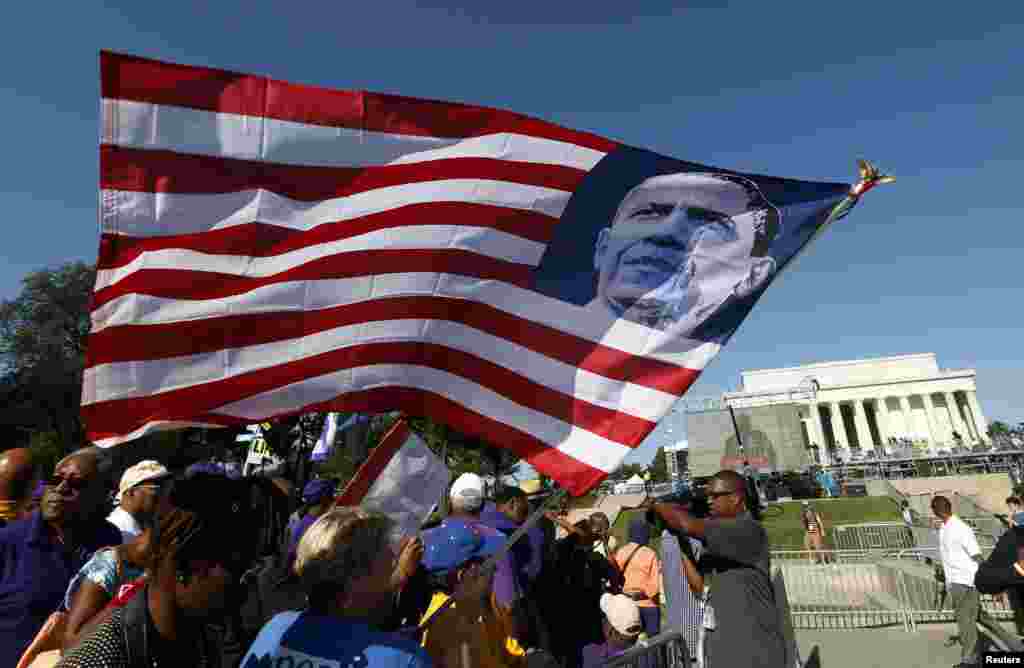 A marcher holds an U.S. flag bearing the image of President Barack Obama during the 50th anniversary of the 1963 March on Washington for Jobs and Freedom at the Lincoln Memorial in Washington Aug. 24, 2013.