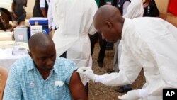 Seorang petugas medis menyuntikkan vaksin ebola kepada seorang warga di Conakry, Guinea (7/3).