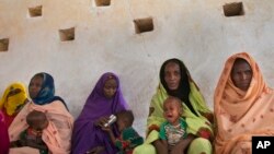 FILE - Mothers wait for their children to be examined for signs of malnutrition at a walk-in nutrition clinic in Africa, April 20, 2012. 