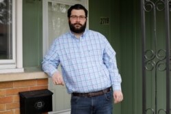 Jonathan Grieder, a high school social studies teacher who serves on the Waterloo City Council, stands on the front porch of his Iowa home, May 1, 2020. “We were failed by people who put profit margins and greed before people."