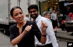 Alexandria Ocasio-Cortez menyapa para pejalan kaki di New York, Rabu, 27 Juni 2018.