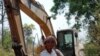 Puth La, 62, an ethnic minority Suy woman, standing next to a digger that villagers say is being used by a Singaporean company in the province of Kampong Speu, three hours drive south-west of the capital Phnom Penh, Cambodia, 17 Feb 2010