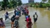People move past a flooded road in Thrissur, in the southern Indian state of Kerala, Aug. 17, 2018. 