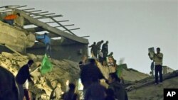 Moammar Gadhafi supporters inspect damage following an airstrike in Tripoli, Libya. The airstrike on Gadhafi's sprawling residential compound early Monday badly damaged two buildings, including a structure where Gadhafi often held meetings, guards at the 