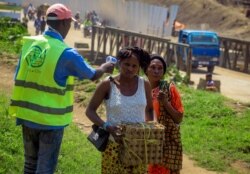 People crossing the border have their temperature taken to check for symptoms of Ebola, at the border crossing near Kasindi, eastern Congo, June 12, 2019, just across from the Ugandan town of Bwera.