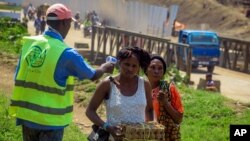 People crossing the border have their temperature taken to check for symptoms of Ebola, at the border crossing near Kasindi, eastern Congo, June 12, 2019, just across from the Ugandan town of Bwera.