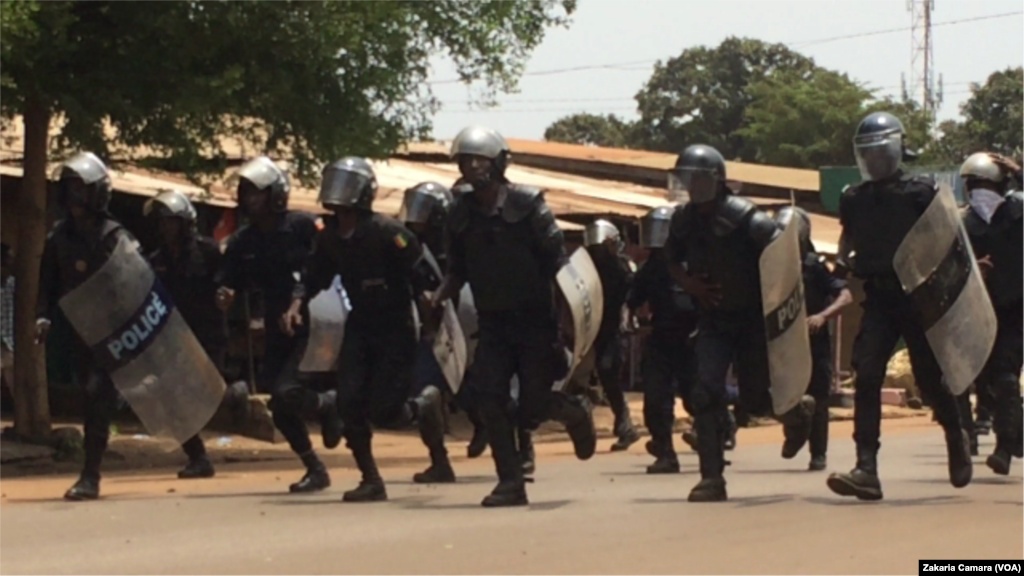 Des policiers essaient de stopper la marche qui se dirige vers l'autoroute, lors d'une manifestation à Conakry, en Guinée, le 22 mars 2018. (VOA/Zakaria Camara)