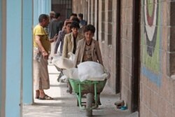 Displaced Yemenis receive food supplies provided by the World Food Program, at a school in Sana'a, Aug. 25, 2019.