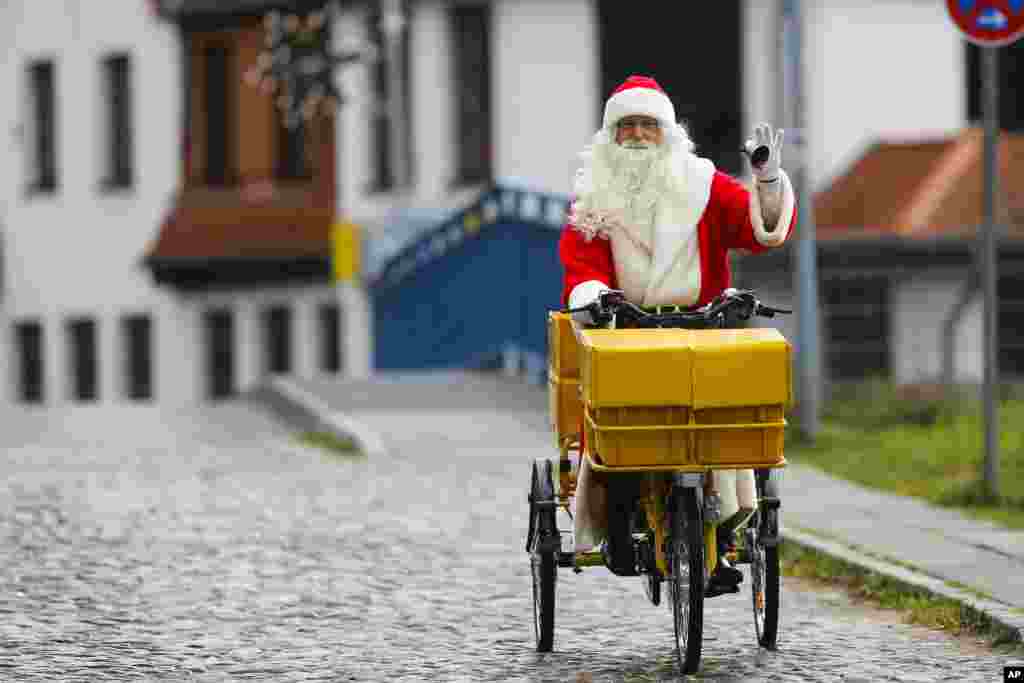 Seorang pria berpakaian sebagai Santa Claus mengendarai sepeda untuk memeriahkan pembukaan kantor surat Natal yang paling terkenal di desa kecil Himmelpfort (yang berarti 'Pintu Surga') di utara Berlin, Jerman.