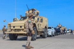 FILE - Saudi forces stand guard during the arrival of Yemen's Prime Minister in Aden, Nov. 18, 2019.