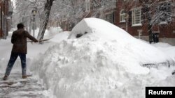 A Boston, dans le Massachusetts, un habitant tente bravement de déblayer le trottoir