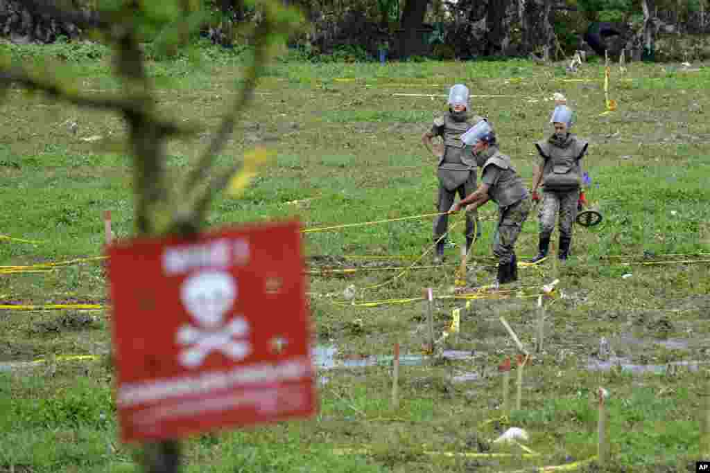 Soldiers repair mine warning signs in fields near the banks of the river Bosnia that flooded near the town of Visoko, Bosnia-Herzegovina, May 20, 2014.