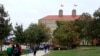 FILE - Students walk in front of Fraser Hall on the University of Kansas campus in Lawrence, Kan. Students cite the cost of flights, and worries about visa renewal as the main reasons for not traveling. 