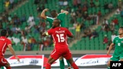 Pesepak bola Palestina (tengah) mengincar bola dengan pemain Irak dalam pertandingan persahabatan internasional antara Irak dan Palestina di Stadion Olahraga Kota Basra, 8 Mei 2018.
