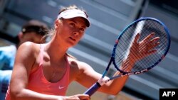 FILE - Russian tennis player Maria Sharapova touches her racket at the end of her match against Colombian Mariana Duque Marino in Madrid, Spain, on May 5, 2015. 