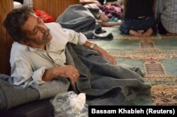 FILE - A survivor of what activists said was a gas attack rests inside a mosque in the Douma suburb of Damascus, Syria, Aug. 21, 2013.