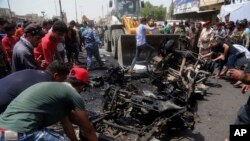 Des civils aident la municipalité a nettoyé la rue après un attentat à la voiture piégée dans un marché, dans la ville de Bagdad, Irak, le 11 mai 2016. 