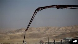 Palestinian men work on a construction site in the West Bank Jewish settlement of Maale Adumim, near Jerusalem, 14 Nov 2010