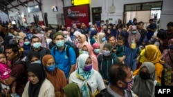 Para penumpang kereta api mengenakan masker sebagai pencegahan virus corona, di stasiun di Surabaya, 15 Maret 2020. (Foto: ilustrasi)