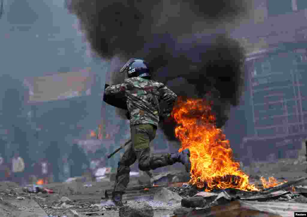 Un policier pourchasse des manifestants pro-Raila Odinga durant les troubles éclatés après la publication de la victoire du président sortant Uhuru Kenyatta à Mathare, Nairobi, Kenya, 12 août 2017.