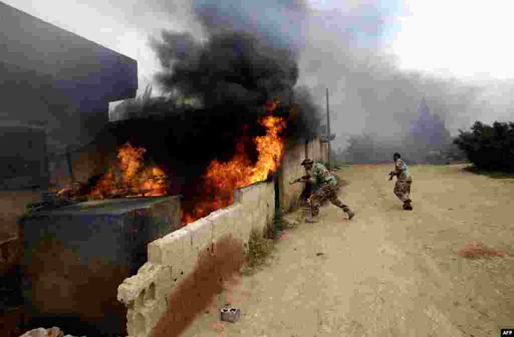 Syrian army soldiers inspect a house as they advance in on the village of Western Dumayna, near the rebel held city of Qusayr, May 13, 2013.
